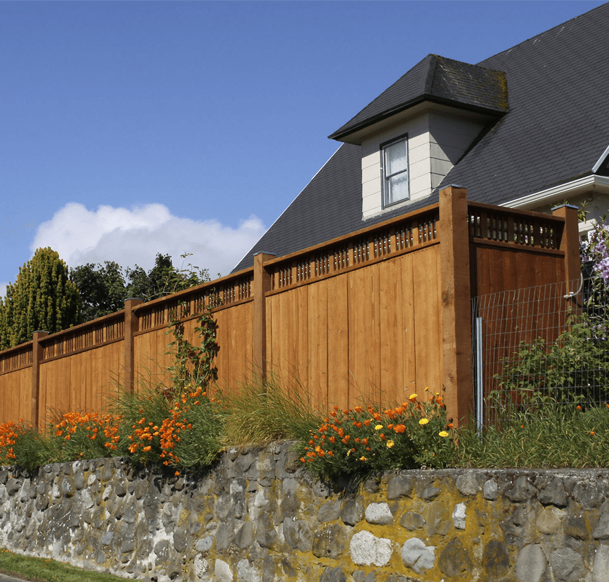 Wooden fence and stone wall by house