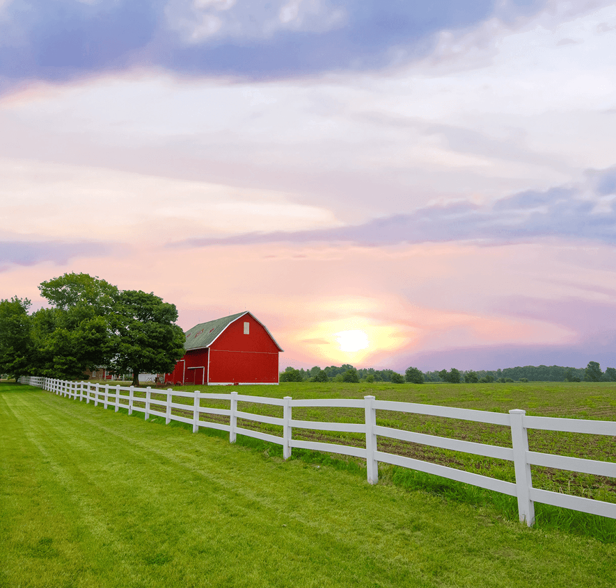 Red barn at sunset with fence
