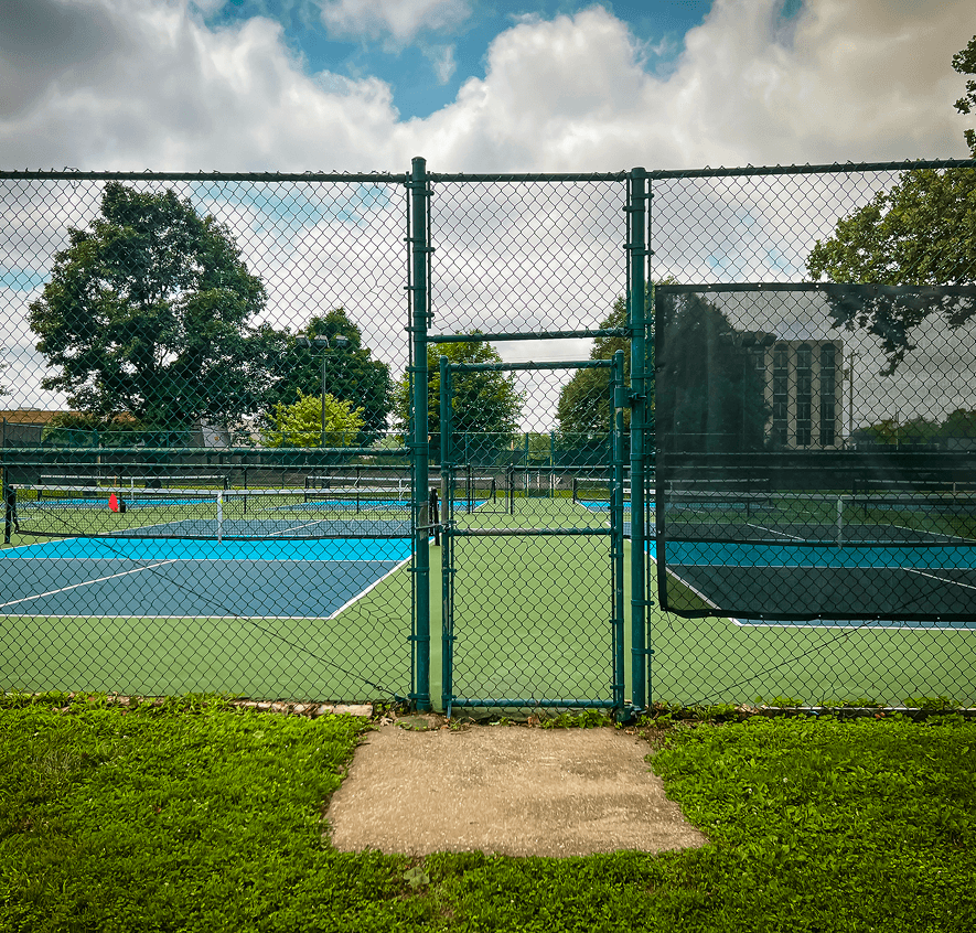 Closed tennis courts with green surroundings