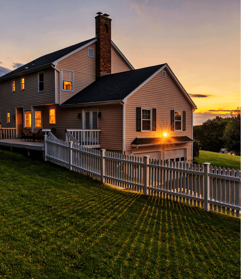 House at sunset with white fence